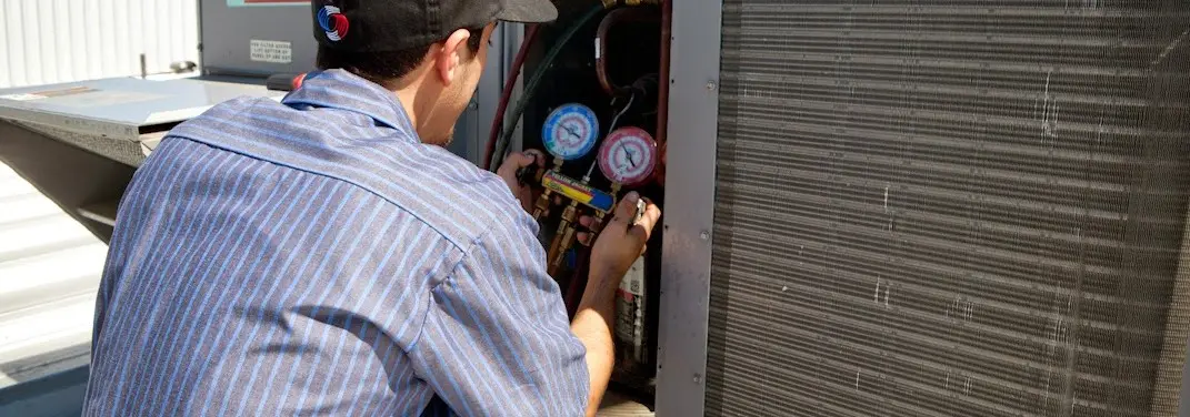 HVAC technician servicing a condenser unit in Breaux Bridge